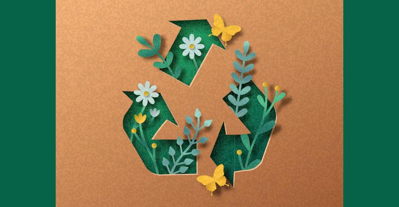 Recyclingzeichen geschmückt mit Blumen vor braunem Papierhintergrund
