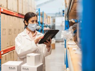 Eine Frau in Arbeitsschutzkleidung verpackt Medizinprodukte