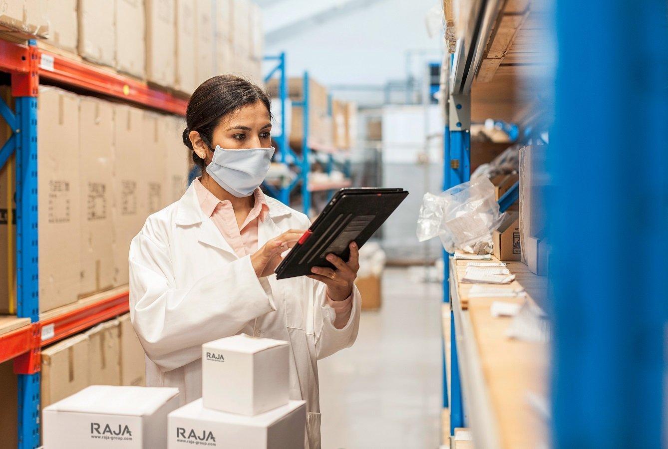 Eine Frau in Arbeitsschutzkleidung verpackt Medizinprodukte